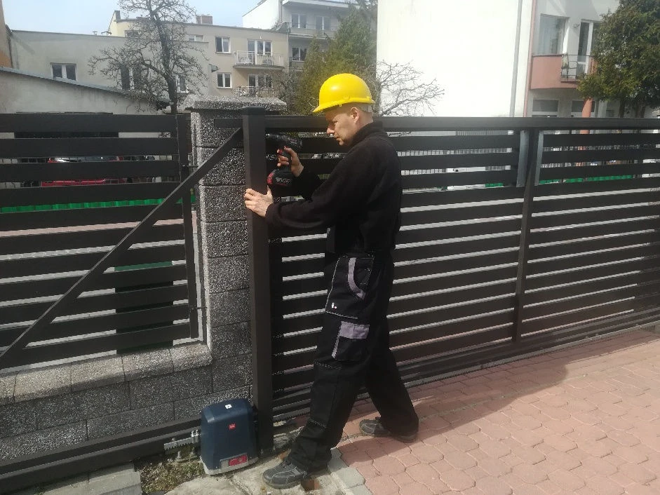 Montaż metalowego ogrodzenia przez pracownika AP art Projekt